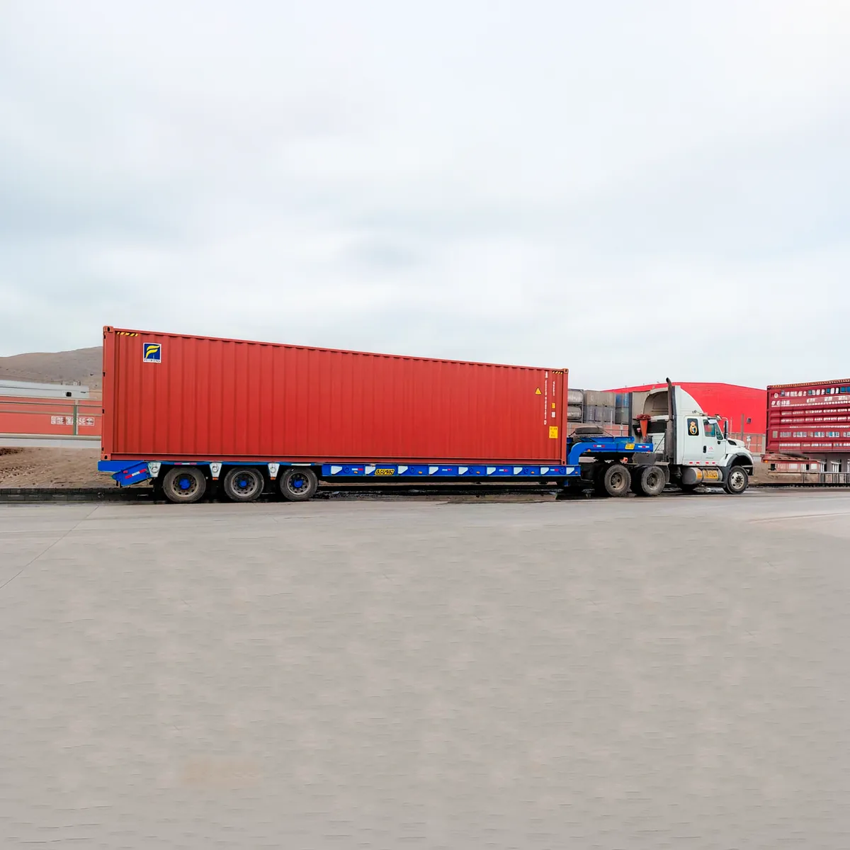 Tracto con plataforma transportando un contenedor